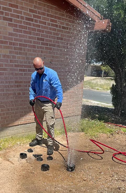 Chris hydro-jetting an exterior cleanout at a Tucson property
