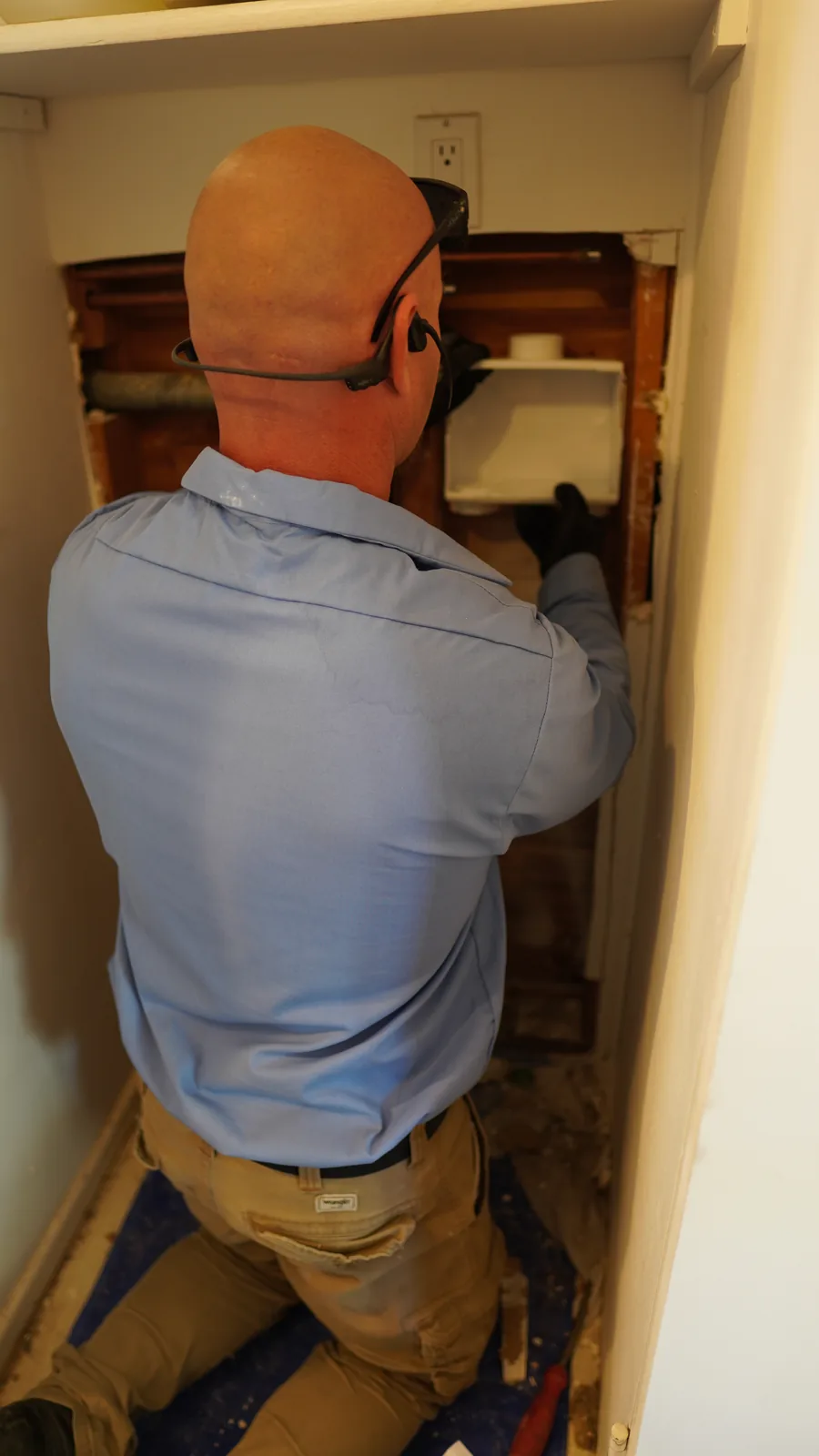 Technician installing a recessed laundry outlet box