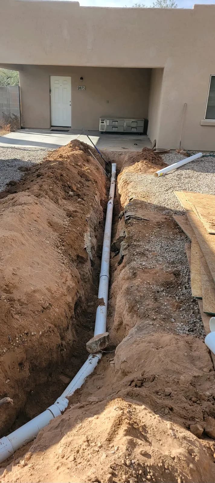 New drain line laid in an open trench before backfill