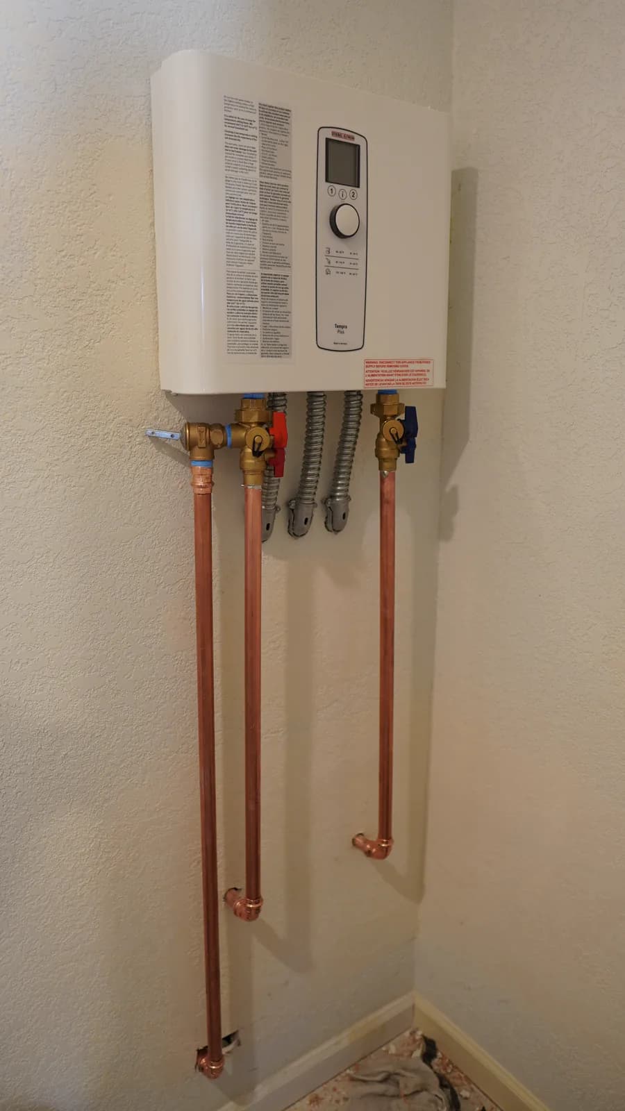Completed tankless water heater installation with copper supply lines
